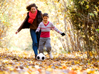 Mother and son running in the trees